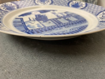 Un plat en porcelaine de Chine en bleu et blanc &agrave; d&eacute;cor de figures dans un int&eacute;rieur, marque et &eacute;poque de Kangxi